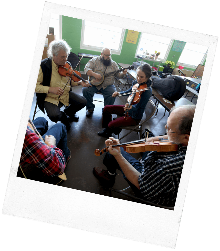 A group jam session with fiddles and banjo